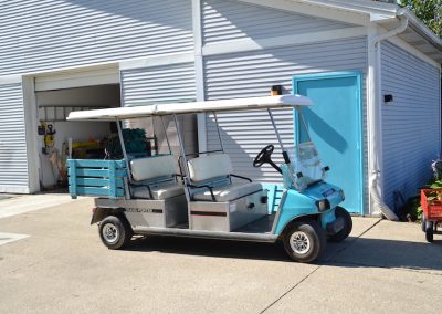A blue and white golf cart parked in front of a building.