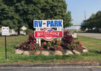 A sign that says rv park and boulders bridge.