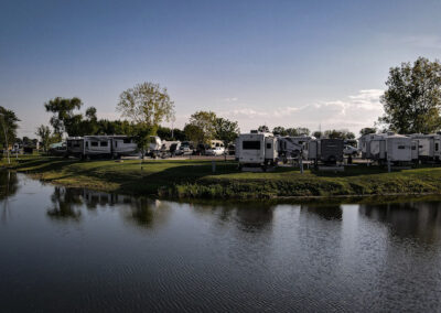 A group of recreational vehicles parked next to the water.